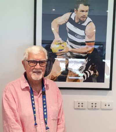 Bob Utber standing in front of a framed image of Patrick Dangerfield