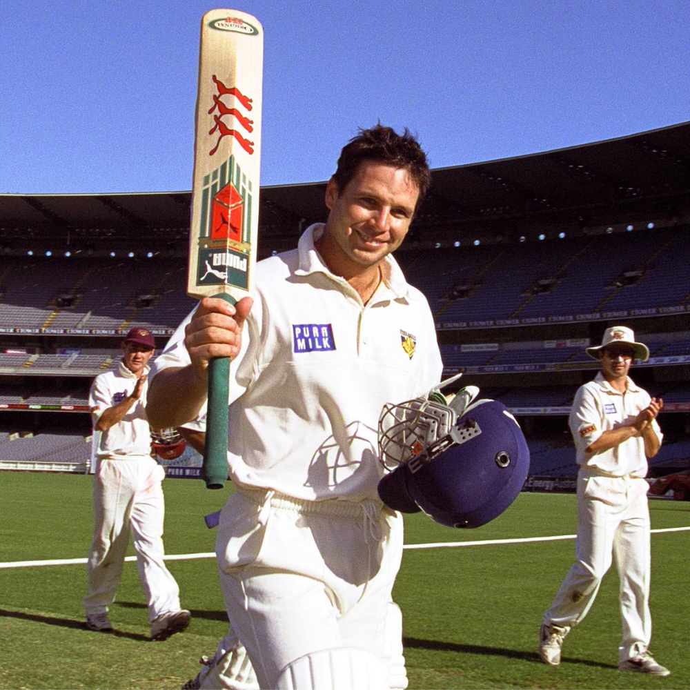 Brad Hodge holding up a cricket bat on the MCG