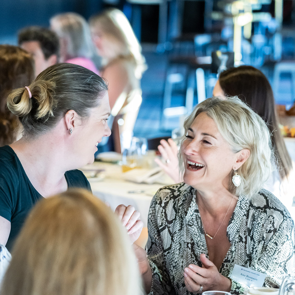 Two women interacting at the Women of the MCC Business Breakfast