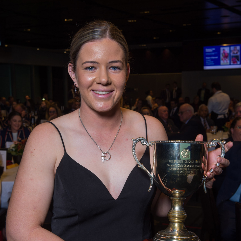 A woman holds a trophy that she has won