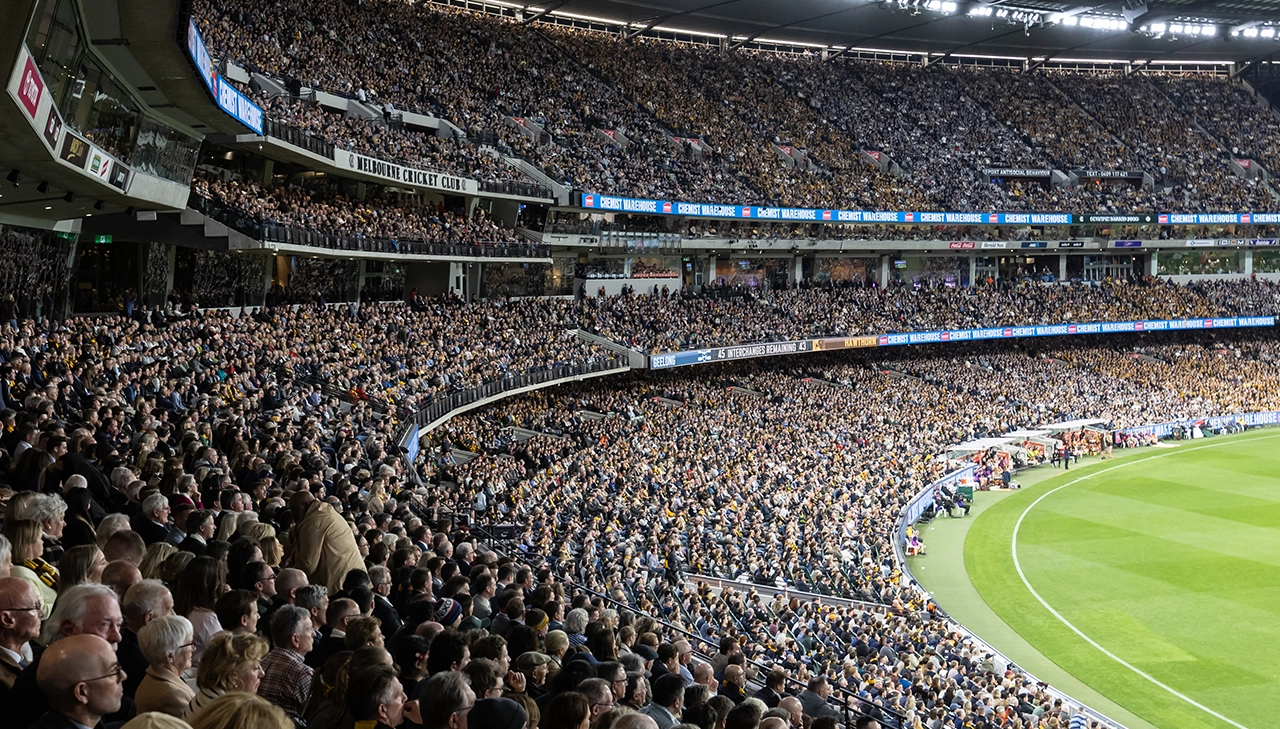 The crowd fills the MCC Members' Reserve at the MCG during a night game AFL25PF_GEELvHAW_337_MCC page banner desktop_1280x729.webp