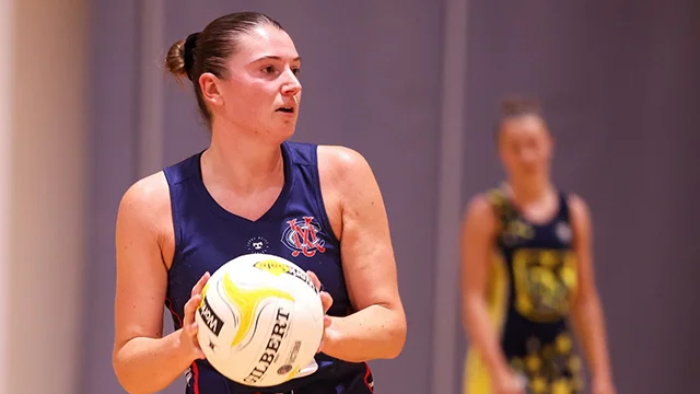 MCC netball player on-court with ball