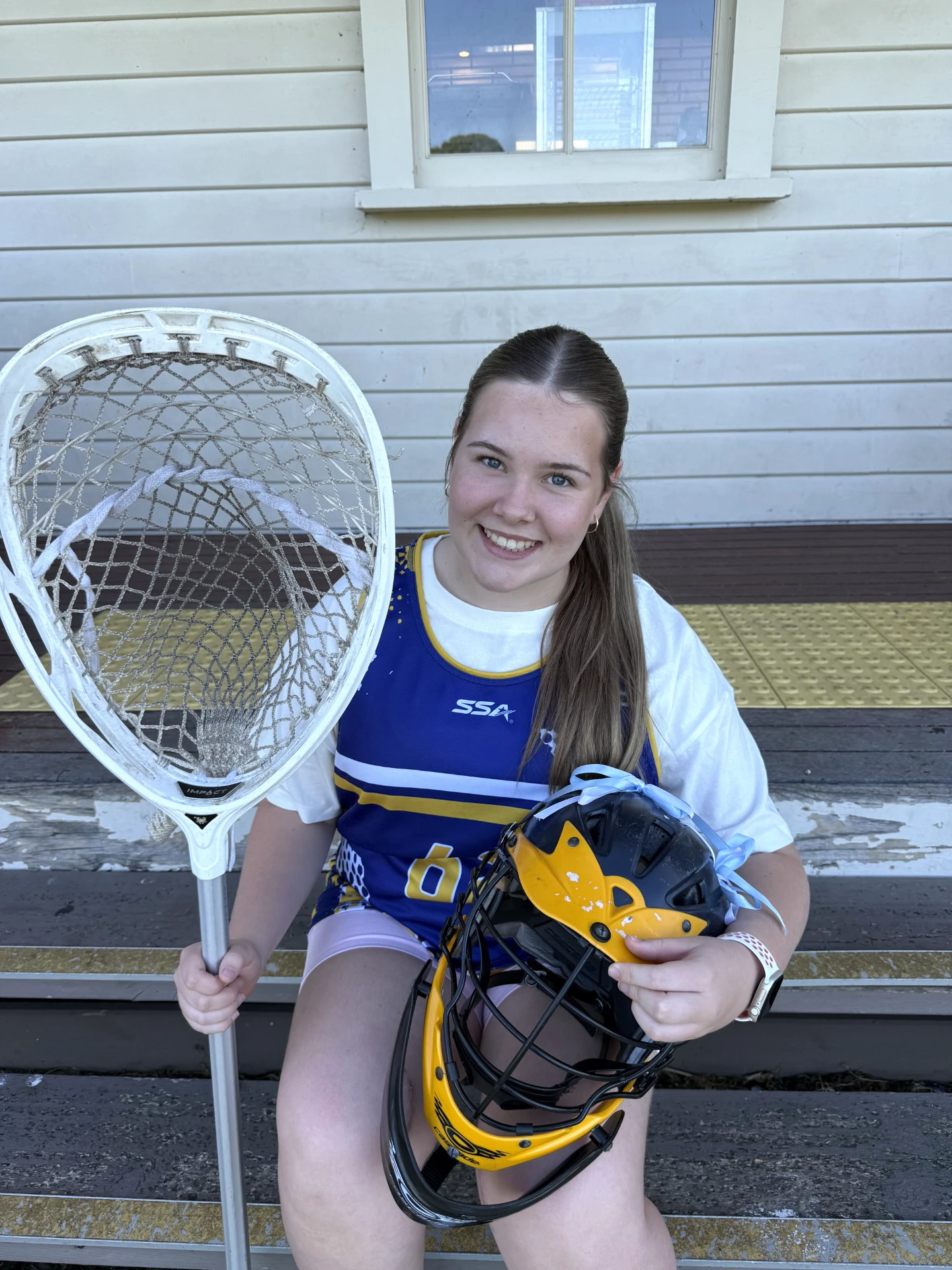 Girl smiling in lacrosse goalie gear