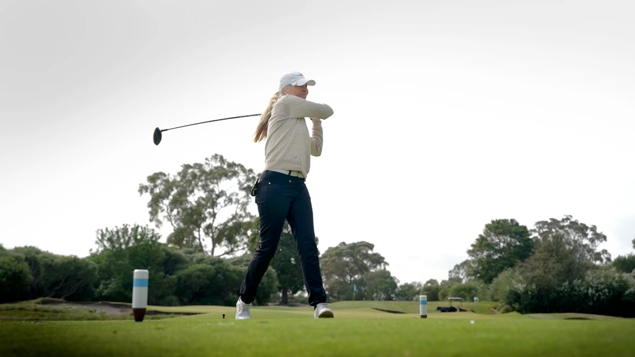 Woman playing golf on course