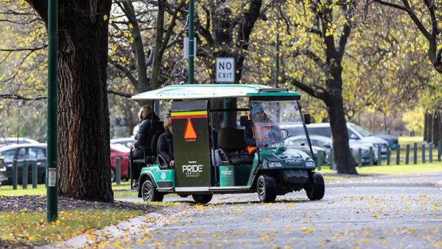 A buggy with passengers drives away from a car park