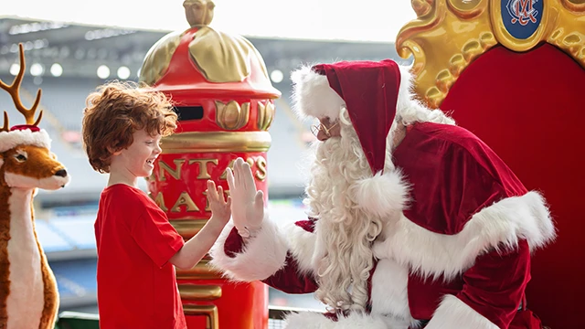 A young boy high-fives Santa