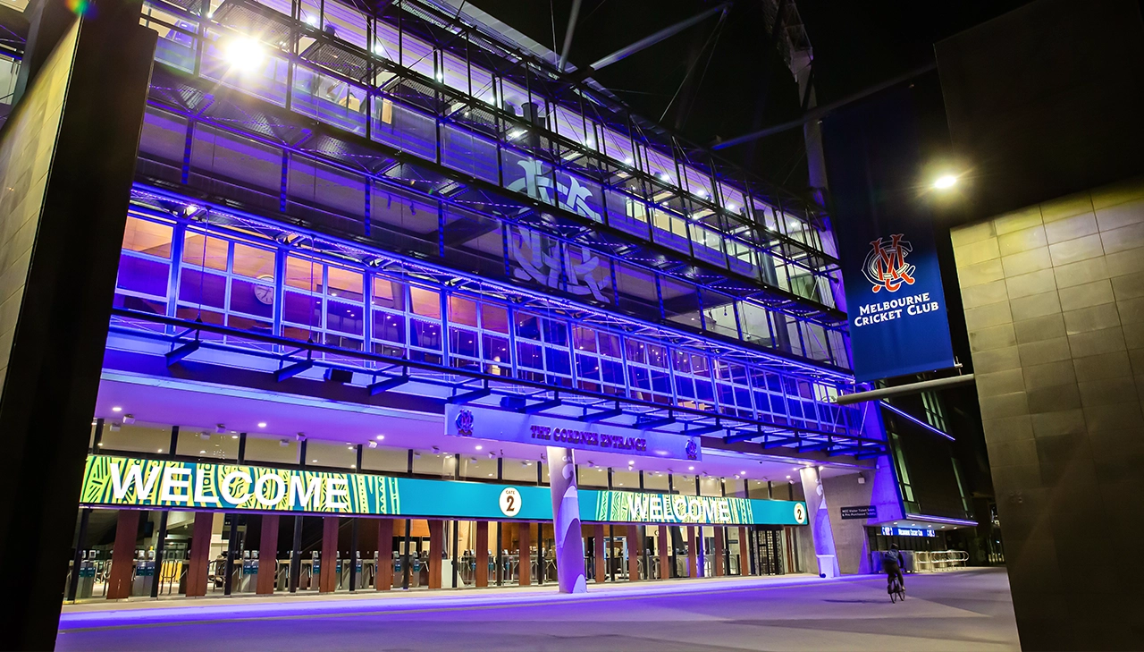 Gate 2 of the MCG lit up in blue at night MCCLIGHTUP_220622_078_MCC page banner desktop_1280x729.webp