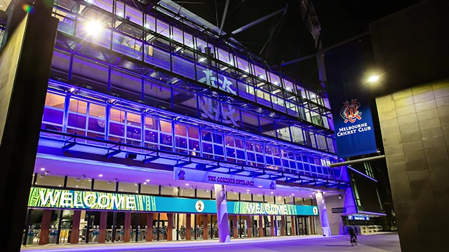 Gate 2 of the MCG lit up in blue at night MCCLIGHTUP_220622_078_Preview Image Card_640x360.webp